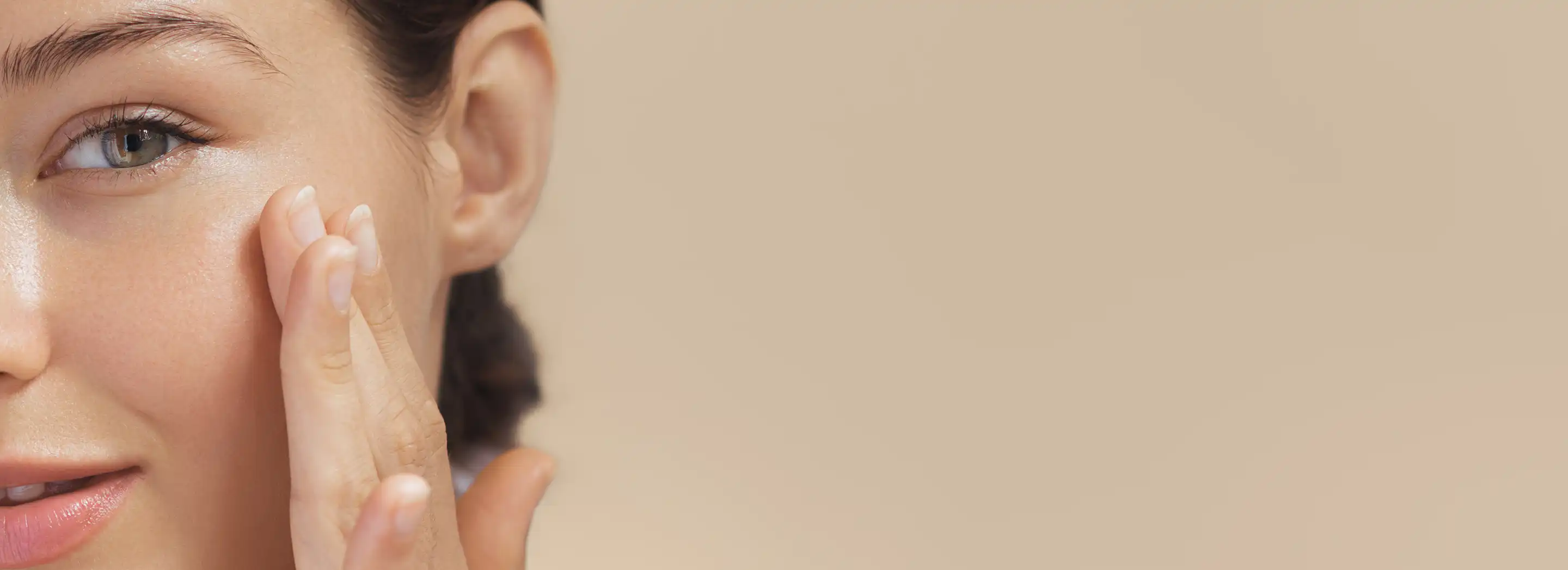 Osoba dotykająca szyi i dekoltu na neutralnym tle, ilustrująca temat mikrobiomu sk&oacute;ry i jego wpływu na kondycję oraz zdrowie sk&oacute;ry.