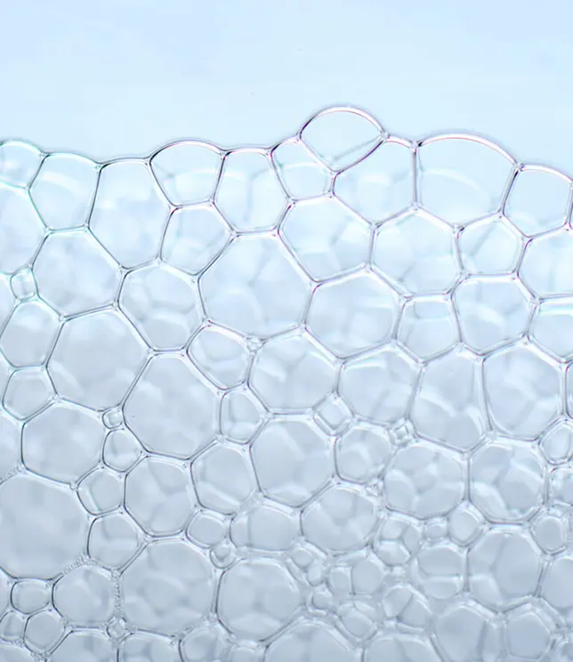 Struktura przezroczystych bąbelków na jasnym tle.