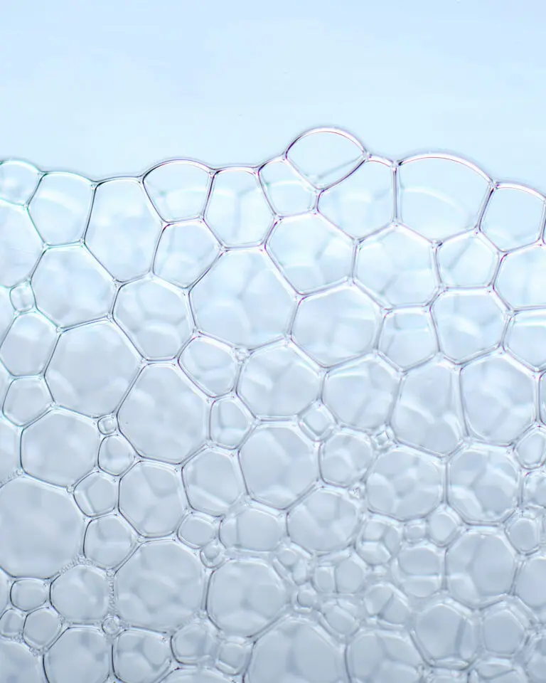 Struktura przezroczystych bąbelków na jasnym tle.