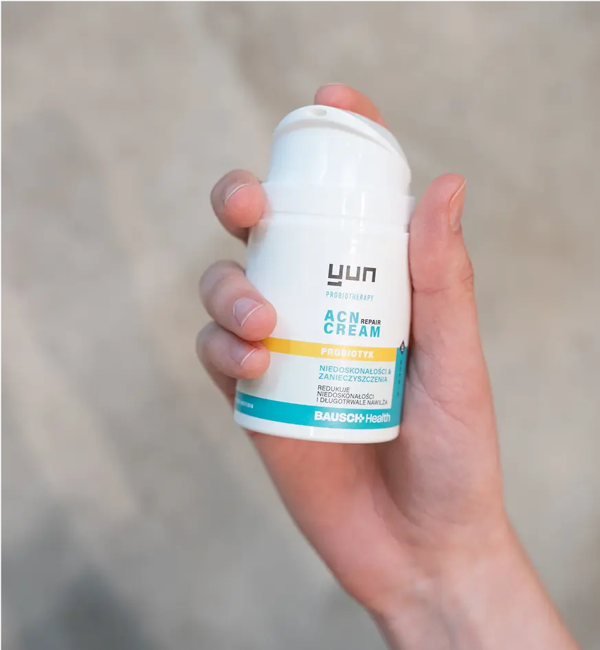 Ręka trzymająca opakowanie kremu Yun ACN Repair Cream